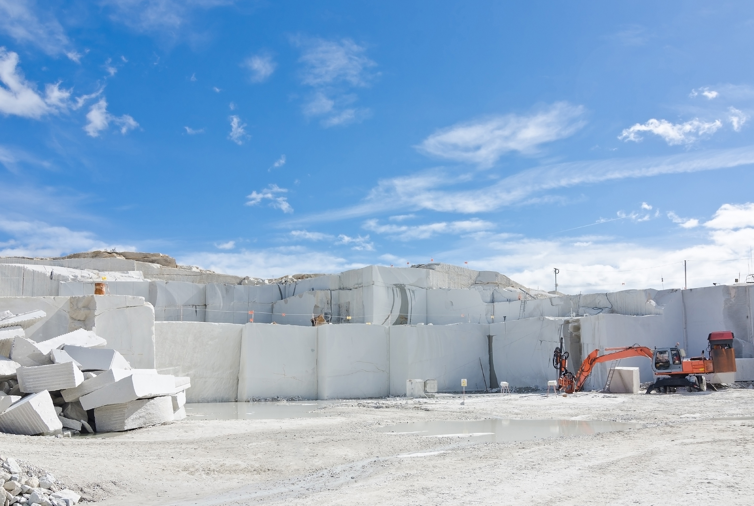 A man standing next to a pile of white marble.