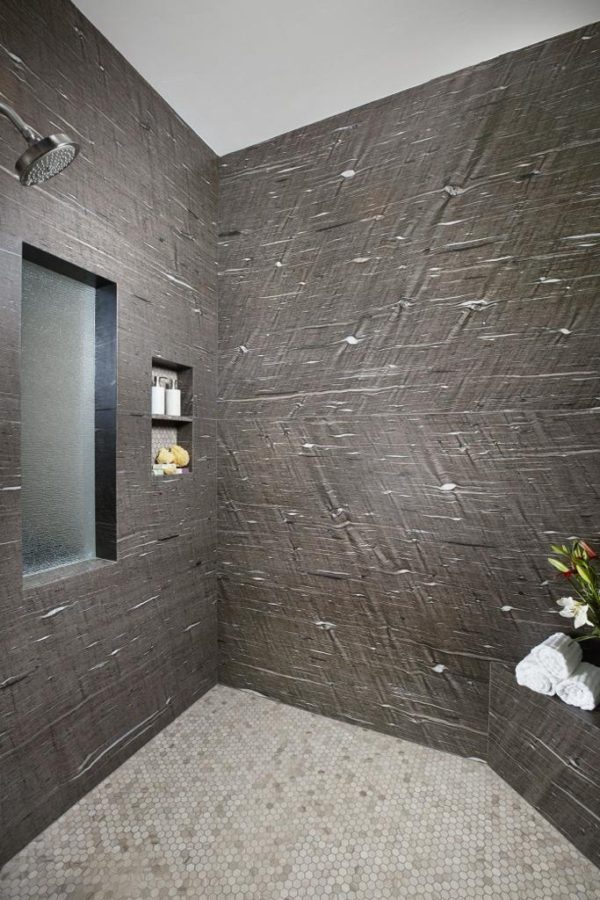A bathroom with a large wall of concrete.
