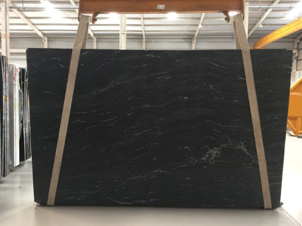 A black marble slab in a warehouse.