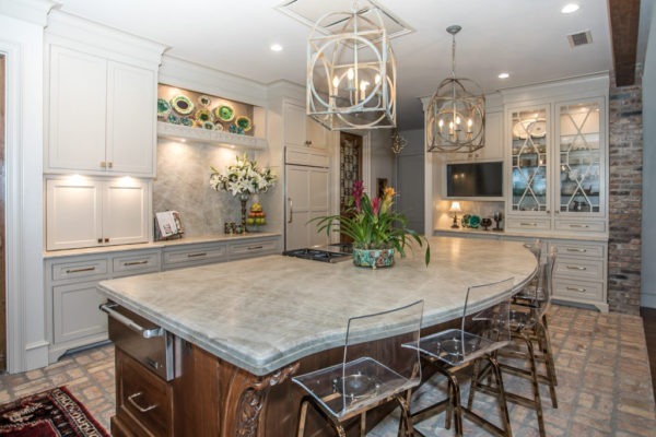 A large kitchen with an island and marble countertops.
