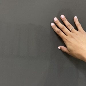A hand is touching the wall with their hands.