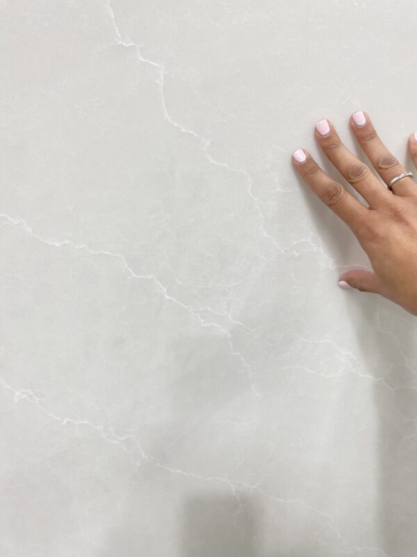 A person touching the wall of a bathroom.