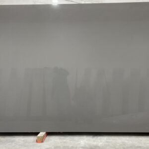 A gray wall with a person standing in front of it.