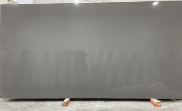 A gray wall with a person standing in front of it.